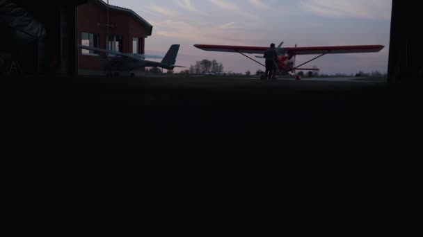 Homem tira um pequeno avião do hangar — Vídeo de Stock