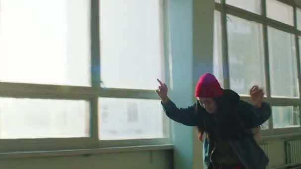 Menina urbana monta em um skate dentro de casa — Vídeo de Stock