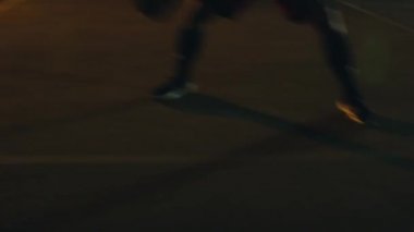 Adam geceleri sokak basketbolu oynuyor.