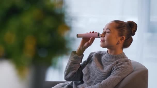 Girl uses face pore vacuum cleaner in office — Stock Video