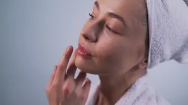 Kız estetik ameliyatlardan sonra yüzüne dokunuyor.