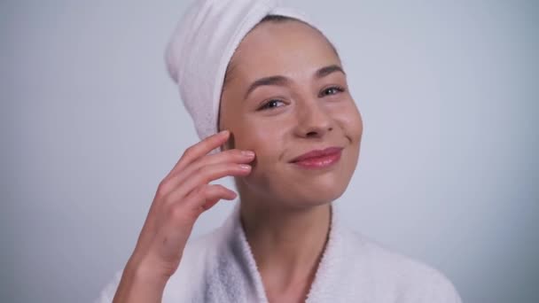 Meisje in een badjas raakt haar gezicht close-up — Stockvideo