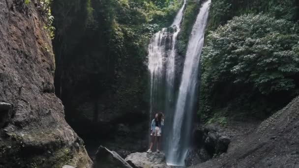 Chica turística en el fondo de una cascada — Vídeos de Stock