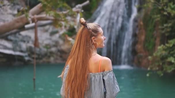 Lány a háttérben egy vízesés — Stock videók