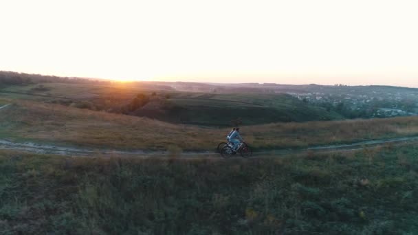 Pareja de ciclistas en el campo al atardecer — Vídeos de Stock