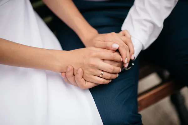 Les mains des couples nouvellement mariés avec des alliances — Photo