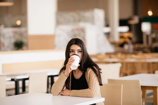 Tiro de uma bela mulher bebendo café no café — Fotografia de Stock