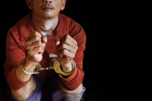 Hands with shackles A man arrested with handcuffs on her hands,Female prisoners were handcuffed on black background