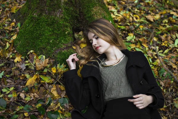 Kız sarı yapraklarda sonbahar kat yatıyor.