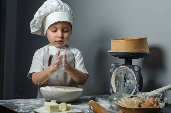 Joyeux garçon drôle enfant prépare la pâte, cuire les biscuits dans la cuisine. Enfant jouant avec de la farine sur la cuisine, battant des mains, fermant les yeux . — Photo