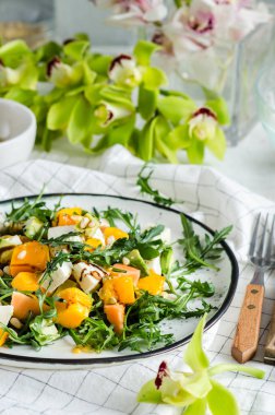 Taze salata roka, mango, papaya, mozzarella, tutku meyvesi ve çam fıstığı..