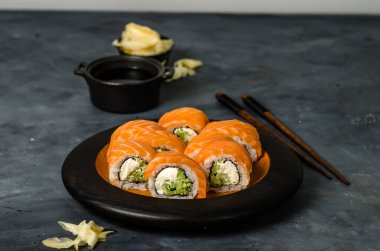 Somonlu Philadelphia suşisi, füme yılan balığı, salatalık, avokado, krem peynir, kırmızı havyar. Suşi menüsü. Japon yemeği..