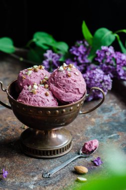 Ev yapımı fındıklı meyveli dondurma. Masada bir demet leylak var..