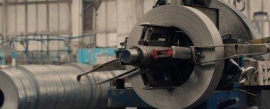 Metal levha oluşturma makinesine bağlı endüstriyel metal bobinler.