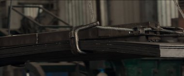 Alüminyum metal levhalar ağır kaldırma hazırlığı için vinç bloğuna bağlanmış büyük tel halat askısı. Heavy Industry Prodüksiyon.