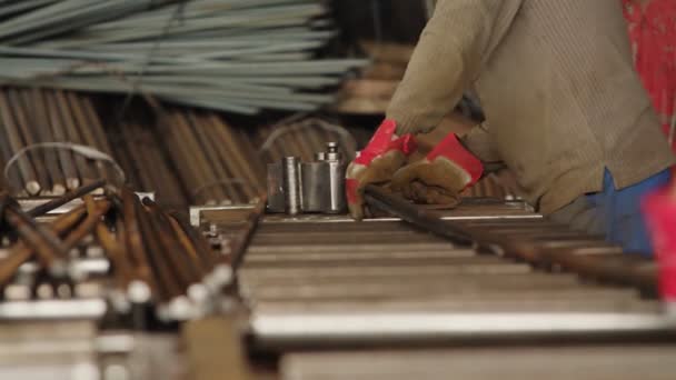 İşçi adam eldiven uzmanı. Paten bükme makinesi kullanıyor. Metal çubuk bükme için endüstriyel bükücü ekipman makinesi. Seçici odak. — Stok video