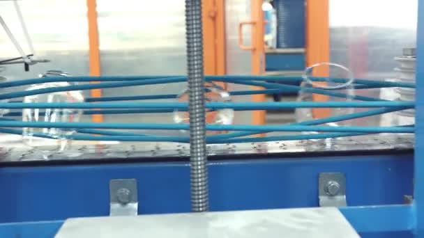 Automatická dopravníková linka nebo pás s řadami průhledných křišťálových nápojových skel v průmyslové výrobě. — Stock video