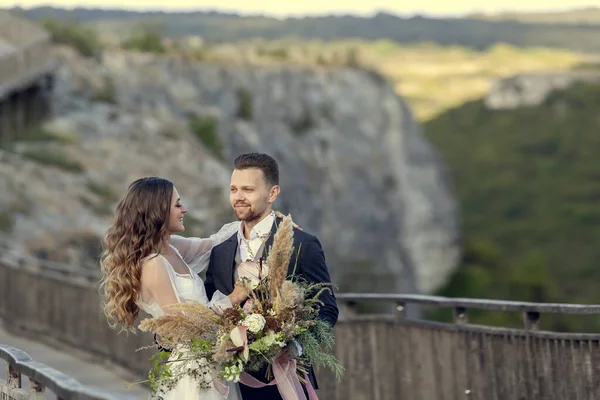 Wedding couple in love staying on bridge in the mountains