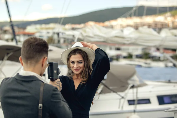 Young man taking a picture of his girlfriend on vintage camera