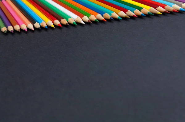 Barevné tužky na černém pozadí, samostatný zblízka — Stock fotografie