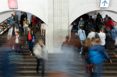 Bulanık hareket. Metroda, tren istasyonunda merdivenlerde bir sürü insan var. İnsanlar büyük salonda merdivenlerden inip çıkıyorlar. Yön insan akışı, kalabalık