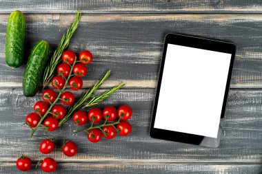 Çeri domatesleri, salatalıklar, biberiye ve tablet siyah masada taklit ediliyor. Sebze. Tarif salatası, vejetaryen menüsü.