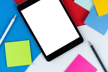 Tablet, e-kitap, Çek bayrağında notlar ve kalemler. Model, kopyalama alanı, desen, karton doku. tablet ve kırtasiye renkli arkaplanda yatar