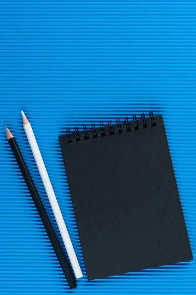 Cuaderno Negro Dos Lápices Sobre Fondo Cartón Ondulado Azul Mock — Foto de Stock