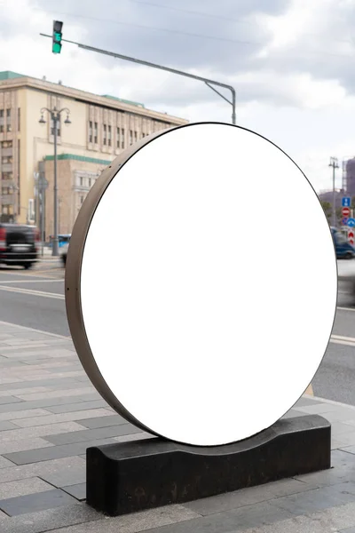 在城市的街道上装上一个圆形灯箱 人行道上的广告设计 复制空间 巴士站附近的圆形广告牌 在背景景观下的城市和道路 — 图库照片