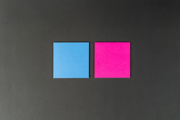Blue and pink notes on black background. Mock up, copy space. concept female and male thoughts, ideas