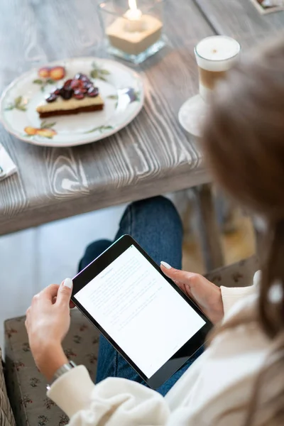 Kahvaltıda kafede e-kitap okuyan bir kız. Samimi bir restoranın masasındaki tablet bilgisayardan gelen metni oku. Çekiş okuma bilgisi