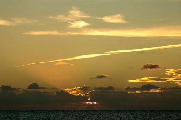 yellow sunset on sea. Clouds in sunset sky. Beautiful view of evening sea