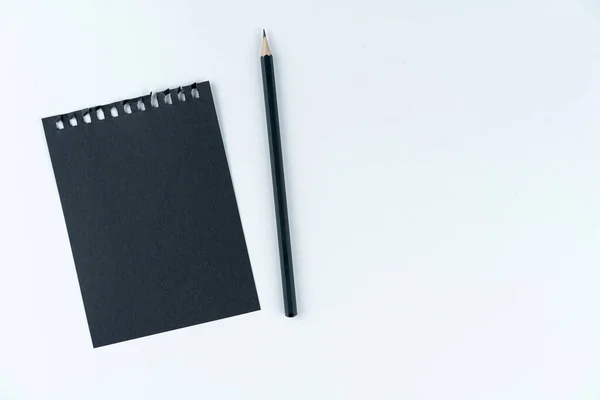Černý List Zápisníku Černá Tužka Leží Bílém Pozadí Textura Lepenky — Stock fotografie