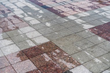 Yağmurdan sonra ıslak kaldırım. Mermer kaldırımda yağmur üstüne su birikintileri. Yağmurdan sonra bir meydanda su birikintileri.
