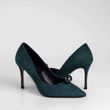 Women green suede high heel shoes with a pearl toe decorative element. Close-up side view studio shot. On a white background for a catalog
