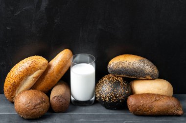 Siyah beton arka planda mini baget ve cam süt. Uzayı kopyala Yemek tarifi. Menü