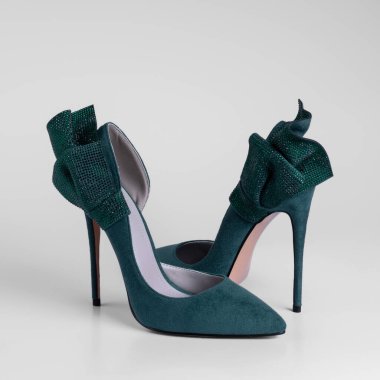 Women's green suede holiday high-heeled shoes with rhinestones decorative trim on a white studio background