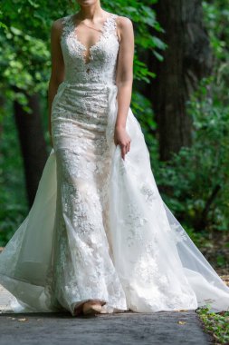 Uzun hava trenli şık bir gelinlik silueti. Çok güzel bir gelinlik balığı. Gelin etkin bir şekilde hareket ediyor, doğada poz veriyor..