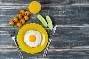 Vişneli domates, salatalık ve portakal suyu ile sarı tabakta kızarmış yumurta. Besleyici bir kahvaltı. Menü veya tarif için boşluk kopyala.