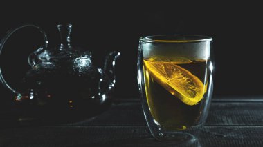 Şeffaf termik bardakta limonlu taze siyah çay. Cam çaydanlık. Çay töreni.