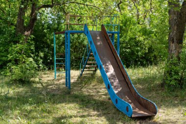 Eski terk edilmiş çocuk parkı. Eski çocukların eğlencesi. Terk edilmiş çocukların eğlence parkı. Paslı çocukların eğlencesi. Yoksulluk. Geçmişe dönük oyun alanı.