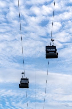 Arka planda mavi gökyüzü ve güneşli yaz havasında beyaz bulutların olduğu kablolar.