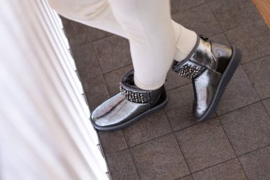 İç modelinde yapay elmasları olan güzel gümüş ugg dişileri. Yan görüş. Ayakkabı mağazası. 