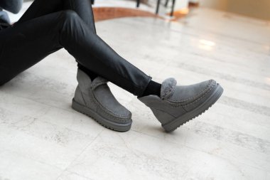 Gri kadın stil uggları. Bacakları içeride dikilmiş.