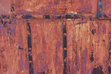 old iron wall consisting of separate pieces of metal. metal patches. Metal sheets from which the area is paint. Iron rusting.