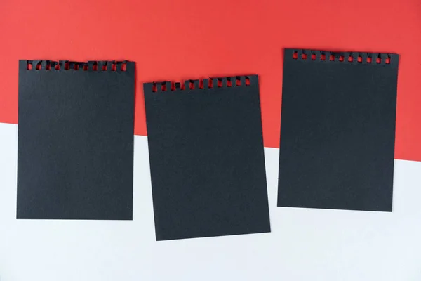 Lista negra de Mónaco. hoja negra de cuaderno se encuentra en la bandera de Mónaco. Maquillaje, espacio de copia, patrón, textura de cartón . — Foto de Stock