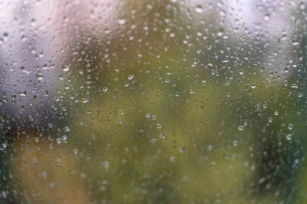 raindrops on glass. Cloudy weather outside window. View of street through glass with raindrops.