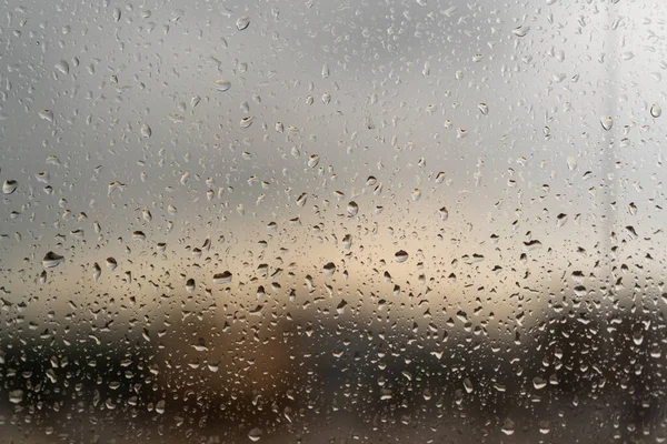 raindrops on glass. Cloudy weather outside window. View of street through glass with raindrops.