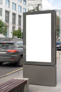 Kentteki dikdörtgen ışık kutusunu düzenle. İnşaat reklamı. Uzayı kopyala Kaldırımdaki dar sokaktaki afiş. Arkaplan inşaatına ve geçen arabaya karşı.