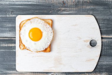 Beyaz kesme tahtasında kızarmış yumurta. Boşluğu kopyala.